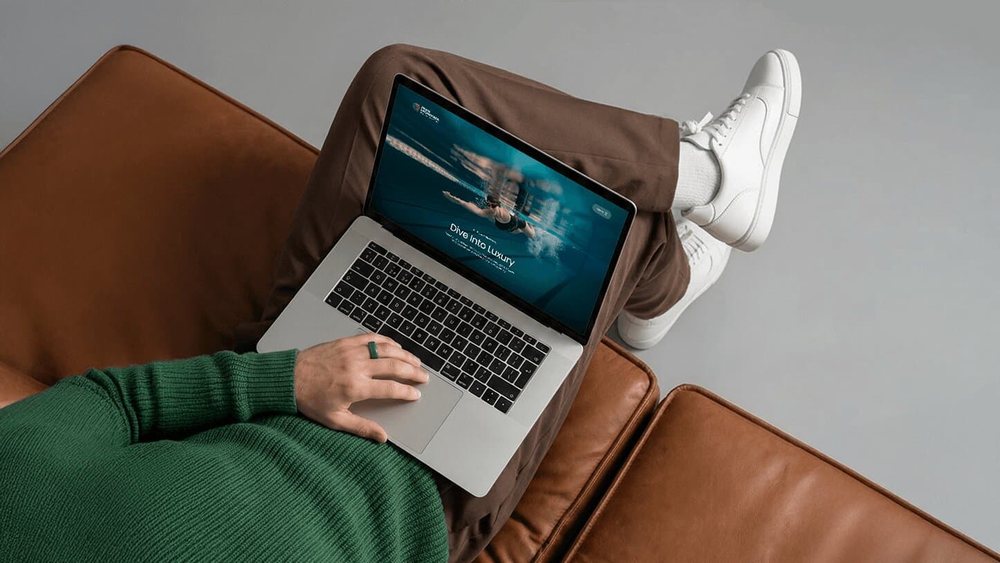 A laptop showing one of the eight amenity landing pages, an underwater swimming pool shot behind "Dive into Luxury"