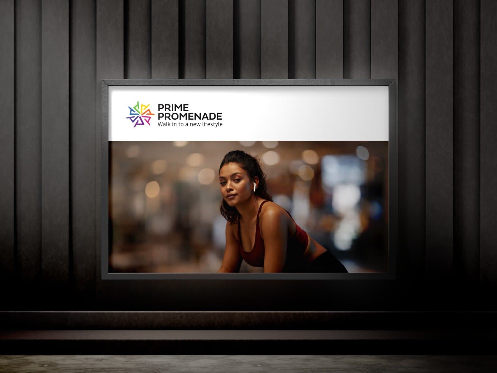 A framed indoor display showing the Prime Promenade logo above a woman resting during a workout