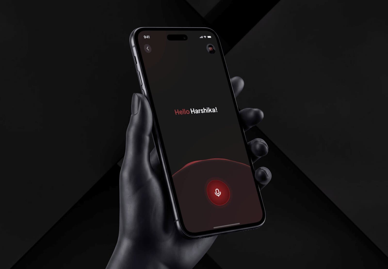 A phone showing a personalized "Hello Harshika!" greeting with a voice-input microphone button